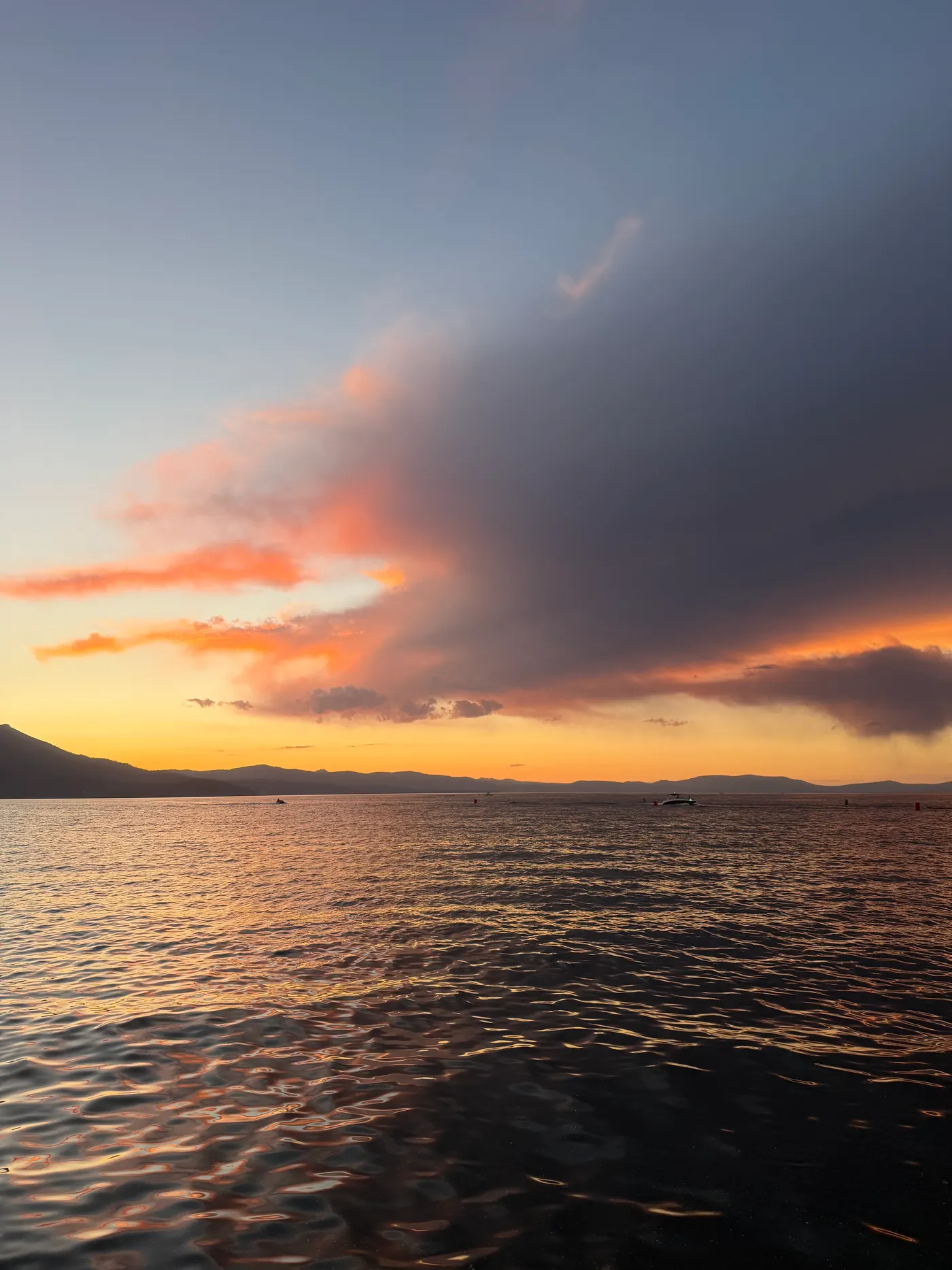 Sunset over Lake Tahoe from the beach — orange sky over the water and mountains